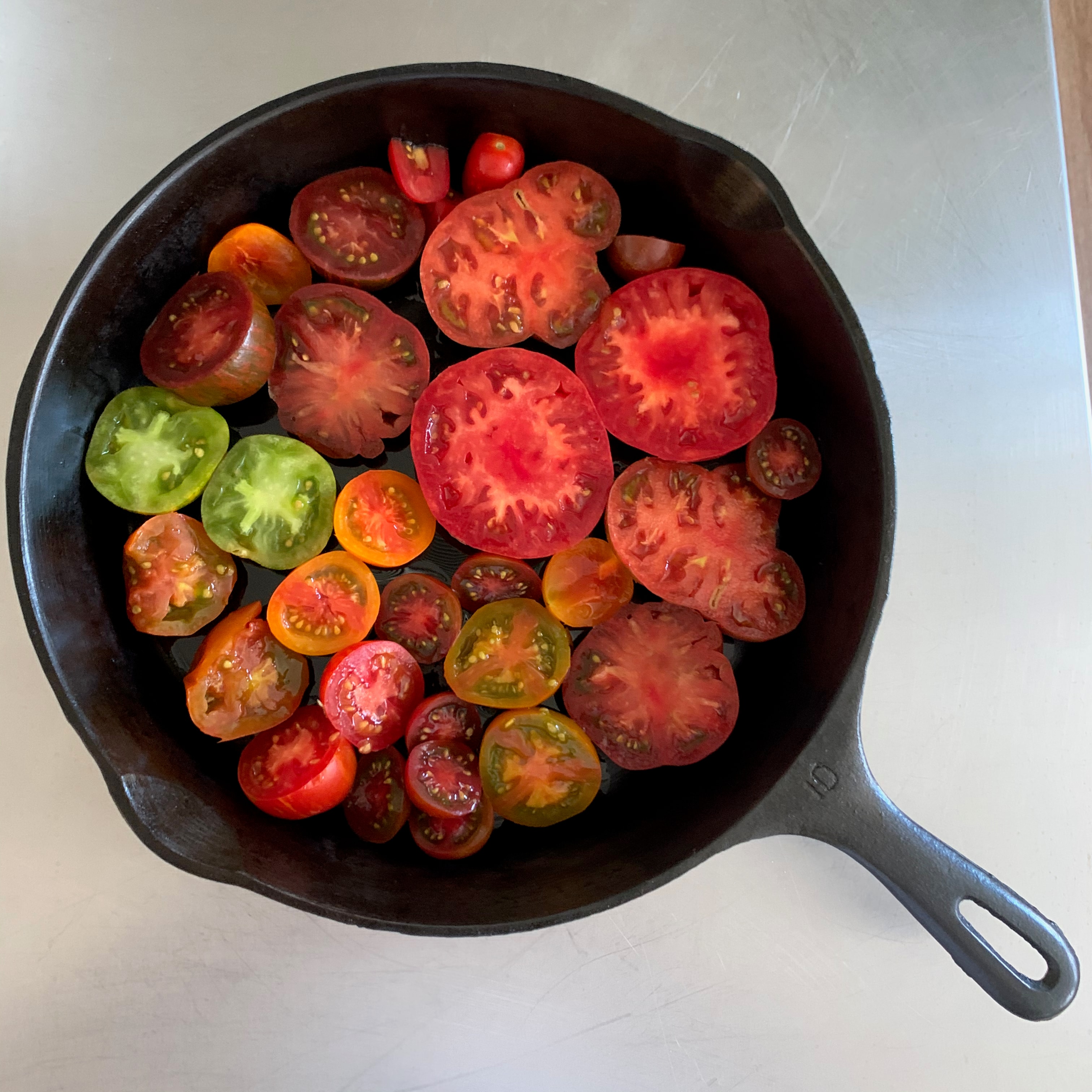 Colorful heirloom tomatoes sliced in a cast-iron skillet